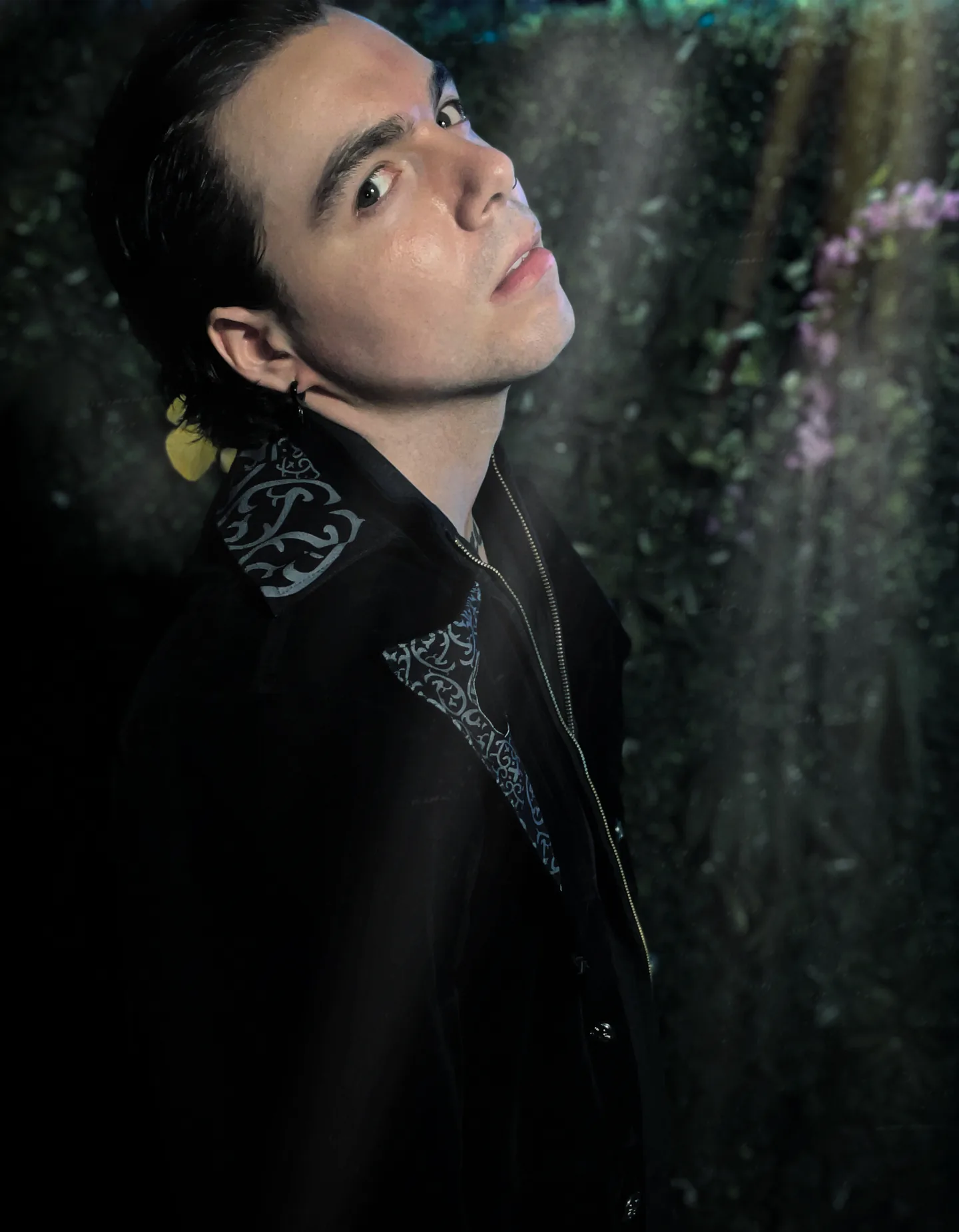 James Laurent photographed against a flower-covered wall